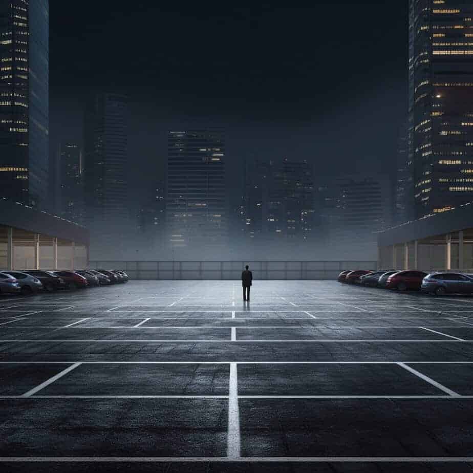 Man walking in an empty parking lot at night